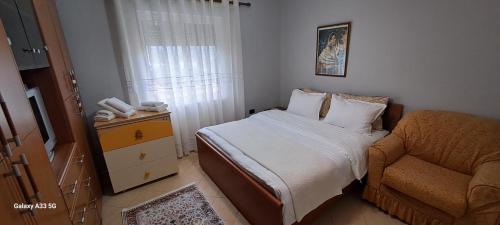 niewielka sypialnia z łóżkiem i krzesłem w obiekcie Tirana country apartment w Tiranie