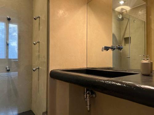 bagno con lavandino e doccia con specchio di Appartamento in centro a Milano