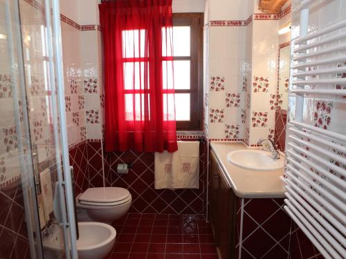 a bathroom with a toilet and a sink and a window at Villa Alba in Marciana Marina