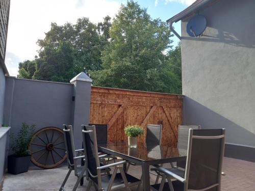 een tafel en stoelen op een patio met een hek bij Pension Kleinschmidt in Urbach