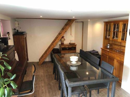 un salon avec une table et des chaises et un escalier dans l'établissement Rez de maison jardin appart, à Saint-Pont