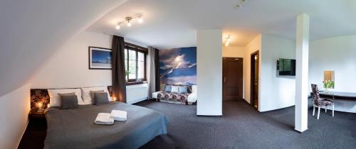 a bedroom with a bed and a desk in a room at Penzion Sileo in Pribylina