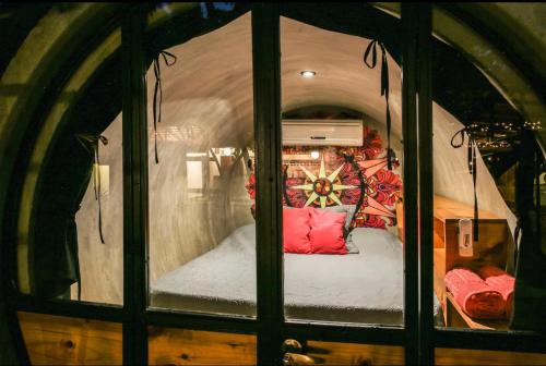 Habitación con cama en el interior de una ventana de cristal. en Pipe House Luxury Beach Glamping Retreat en Barco Quebrado