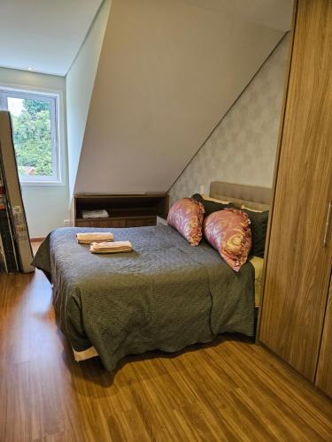 1 dormitorio con 1 cama con 2 almohadas en Gaudi Loft Design, en Campos do Jordão