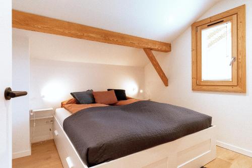 een bed in een kamer met een raam bij Bright & elegant stand alone chalet - 8 ppl - Vois Le Mont in Les Gets
