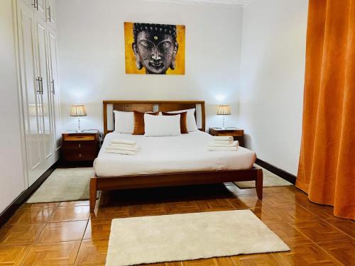 a bedroom with a bed and two night stands at Hollywood villa in Campanário