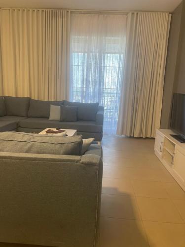 een woonkamer met een bank en een televisie bij مارينا KAEC in King Abdullah Economic City