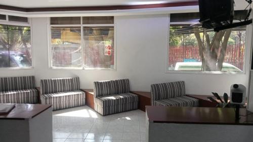 een woonkamer met 2 stoelen en een tafel bij HOTEL PARQUE VIA in Mexico-Stad