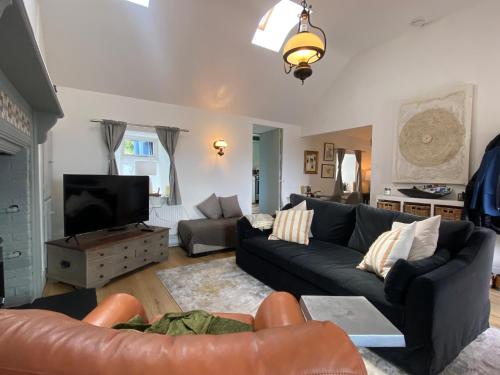 a living room with a couch and a tv at Oranuisce Thatch Cottage Ballyvaughan in Ballyvaughan