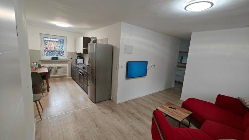 a living room with a red couch and a refrigerator at Ferienwohnung Sorgenfrei - Parkplatz, Balkon & Terrasse in Coburg