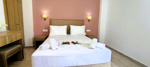 a hotel room with a white bed with flowers on it at Ragias Studios in Tsilivi