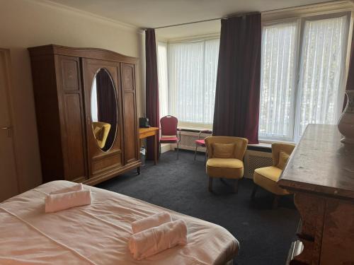 Habitación de hotel con cama y espejo en Hotel Rubenshof, en Amberes