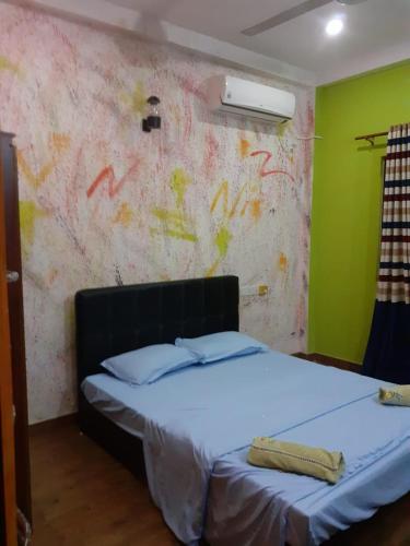 a bedroom with a white bed with a green wall at Rohan's Residence in Kandana