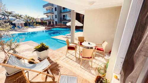 a balcony with a table and chairs next to a swimming pool at Exclusives Apartment Mountainview Residence in Belek