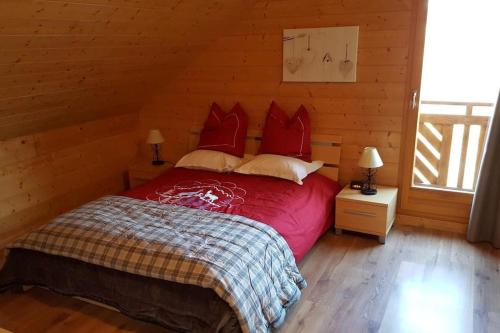 1 dormitorio con 1 cama con sábanas y almohadas rojas en Chalet Airelles 4 pers - Tout Confort - Wifi fibre en Xonrupt-Longemer