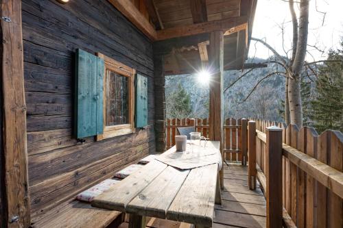 a wooden table on the porch of a cabin at Berg'k'hütte im Kaisertal - Hiking only! in Kufstein
