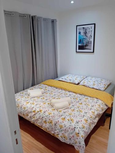 une chambre avec un lit avec deux oreillers dessus dans l'établissement Appart avec jardin proche Paris, à Aubervilliers