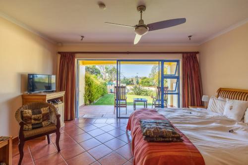 a bedroom with a bed and a sliding glass door at Gästehaus Pinkepank in Plettenberg Bay