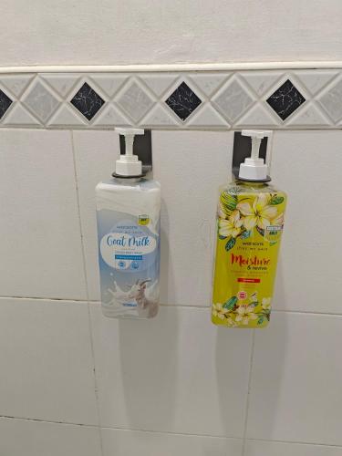 two bottles of cleaning products on a shelf in a bathroom at Best Inn Lahug in Cebu City