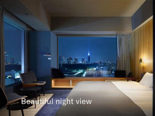 a bedroom with a view of a city at night at sequence MIYASHITA PARK - Shibuya in Tokyo