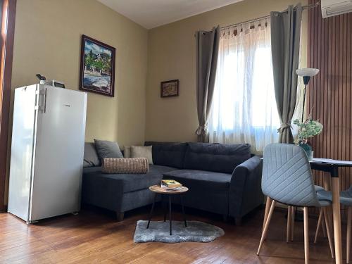 - un salon avec un canapé bleu et un réfrigérateur dans l'établissement Апартаменти за гости ,,Friends", à Teteven