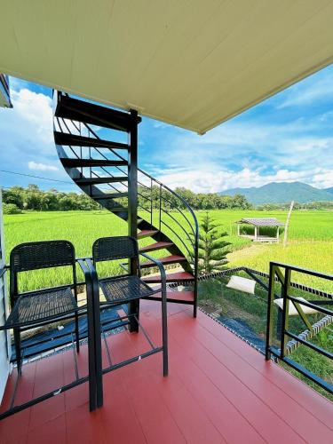 a porch with two benches and a spiral staircase at ฮักดอยคาเฟ่ แคมป์&โฮมสเตย์ สะพานสายรุ้ง จ.น่าน in Chiang Klang