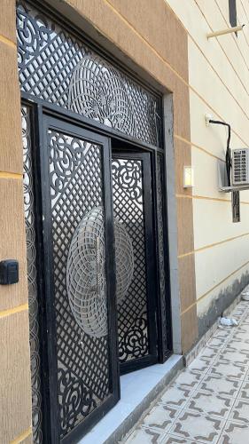 een zwarte ijzeren poort op een gebouw bij شقة مميزه في القنفذة in Al Qunfudhah