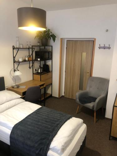 um quarto de hotel com uma cama, uma secretária e uma cadeira em Penzion U Kašpara em Lovosice