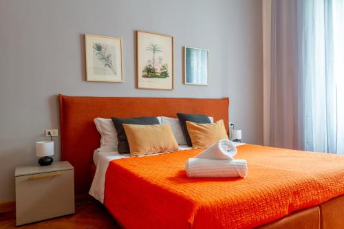 米兰CentralStation - Via Lazzaroni的卧室里有一张床，上面铺着橙色的毯子