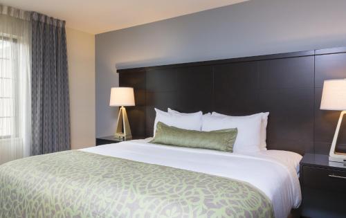 a hotel room with a large bed and two lamps at Staybridge Suites Canton by IHG in North Canton