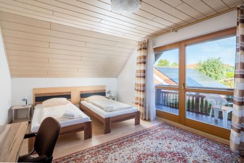 1 dormitorio con 1 cama y balcón en Unterkunft DHH mit 5 Zim, en Schmatzhausen