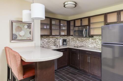 a kitchen with wooden cabinets and a white counter top at Staybridge Suites Canton by IHG in North Canton