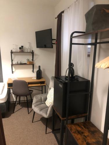 a room with a desk and a bunk bed with a chair at Penzion U Kašpara in Lovosice