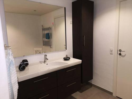 a bathroom with a sink and a large mirror at Amazing Sea and Mountain View in Klaksvík