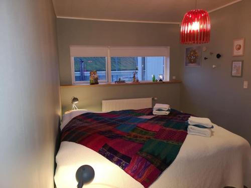 a bedroom with a bed with a colorful blanket on it at Amazing Sea and Mountain View in Klaksvík