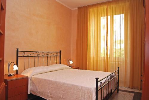 a bedroom with a bed and a window with yellow curtains at Maestoso Locazione Turistica in Rome