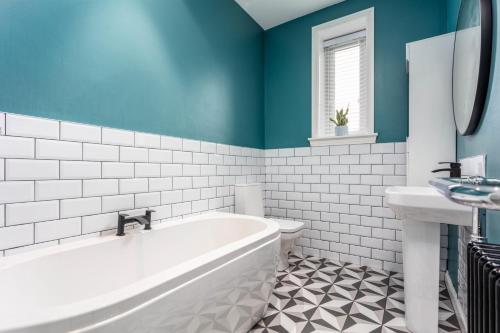 a bathroom with a tub and a toilet and a sink at Berelands House - Donnini Apartments in Prestwick