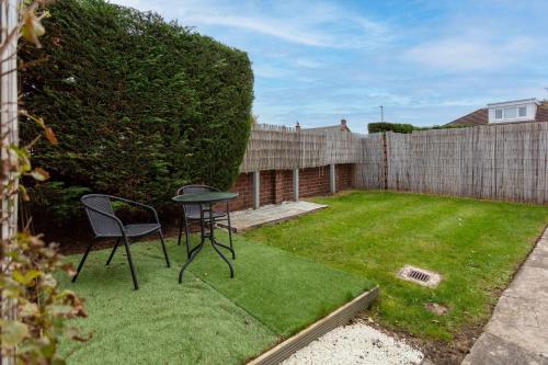 a small yard with a table and a chair at Berelands House - Donnini Apartments in Prestwick