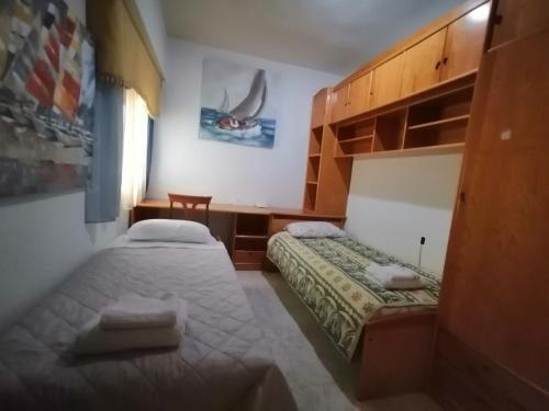 a bedroom with two beds and a table and a chair at ROOMS Beach 5 MIN Playa in Alicante