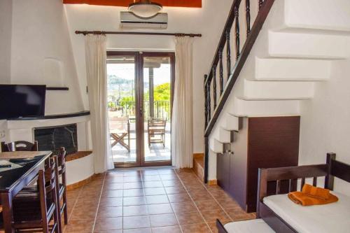 a living room with a staircase leading to a patio at Skiathos Holiday Resort in Skiathos