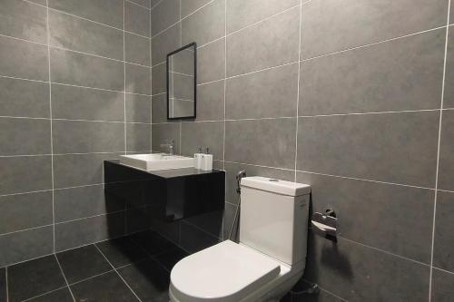 a bathroom with a white toilet and a sink at Sunway Onsen Suites - Theme Park Tambun Ipoh by Ryokan Management in Tambun