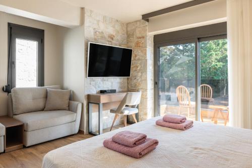 1 dormitorio con 1 cama con 2 toallas en Domenica Diamond Villas, en Chaniotis