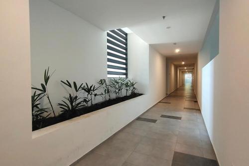 a hallway with white walls and plants on the wall at Sunway Onsen Suites - Theme Park Tambun Ipoh by Ryokan Management in Tambun