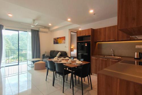 a kitchen and living room with a table and chairs at Sunway Onsen Suites - Theme Park Tambun Ipoh by Ryokan Management in Tambun
