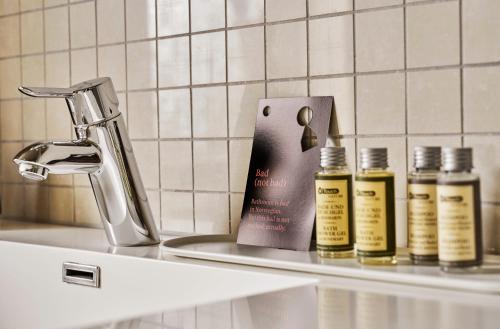 a counter with three bottles of essential oils and a sink at Krüger's Crib By Staysville in Stavanger