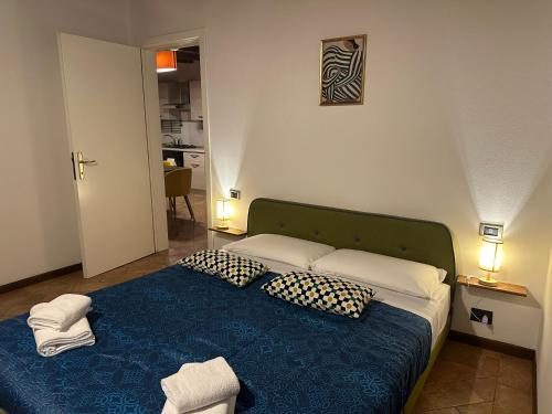 ein Schlafzimmer mit einem blauen Bett mit Kissen in der Unterkunft FEEL - Piazza Pontida Balcony Apartment in Bergamo