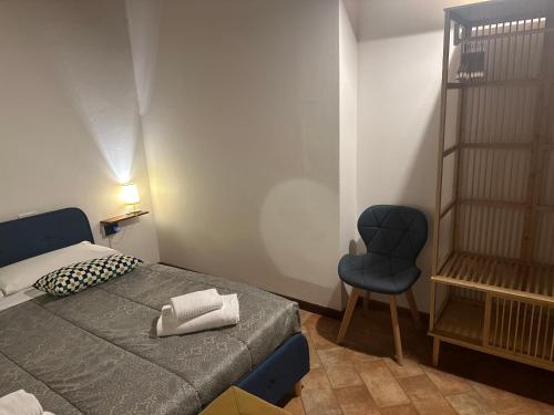 ein Schlafzimmer mit einem Bett und einem blauen Stuhl in der Unterkunft FEEL - Piazza Pontida Balcony Apartment in Bergamo