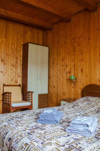 a bedroom with a bed in a room with wooden walls at Kryvorizka Palanka in Mykulychyn