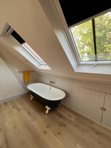 een badkamer met een bad en een raam bij Henley Bolt Hole in Henley on Thames