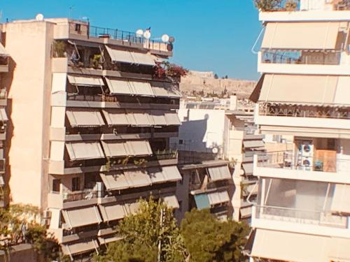 ein hohes Gebäude mit Balkon an der Seite in der Unterkunft Acropolis view Luxury 2-bedroom Condo in Athen